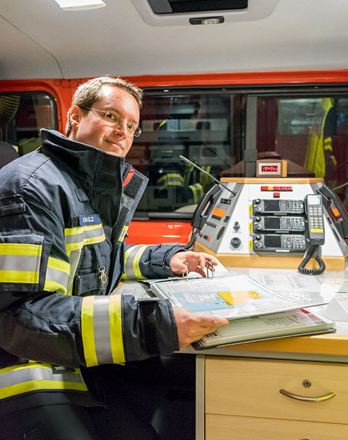 Henrik Schulz in Einsatzkleidung im Einsatzleitwagen an der Funkkonsole